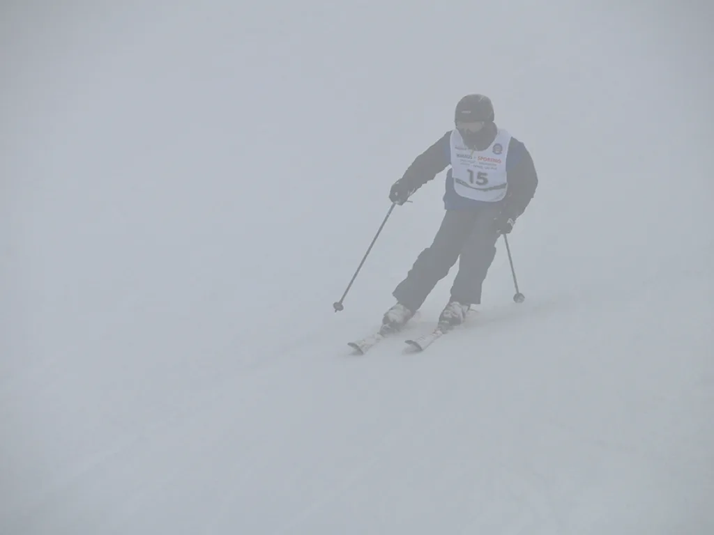 Skifahrer mit Startnummer 15 im Nebel.